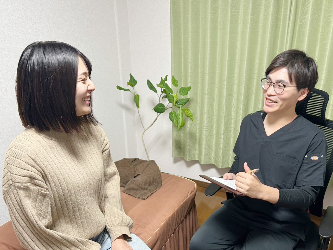 患者にヒアリングを行う施術者