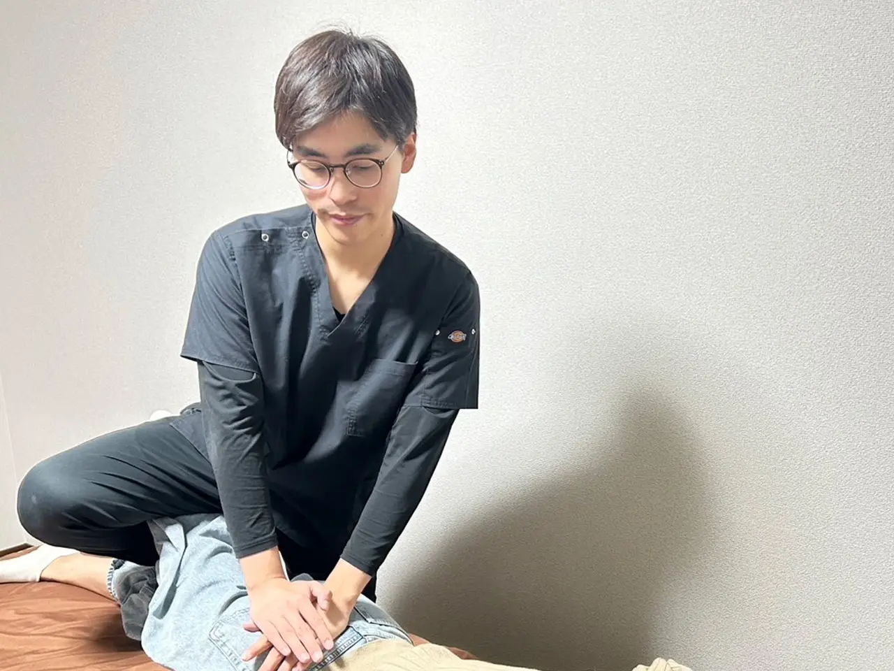 患者の臀部を施術する施術者